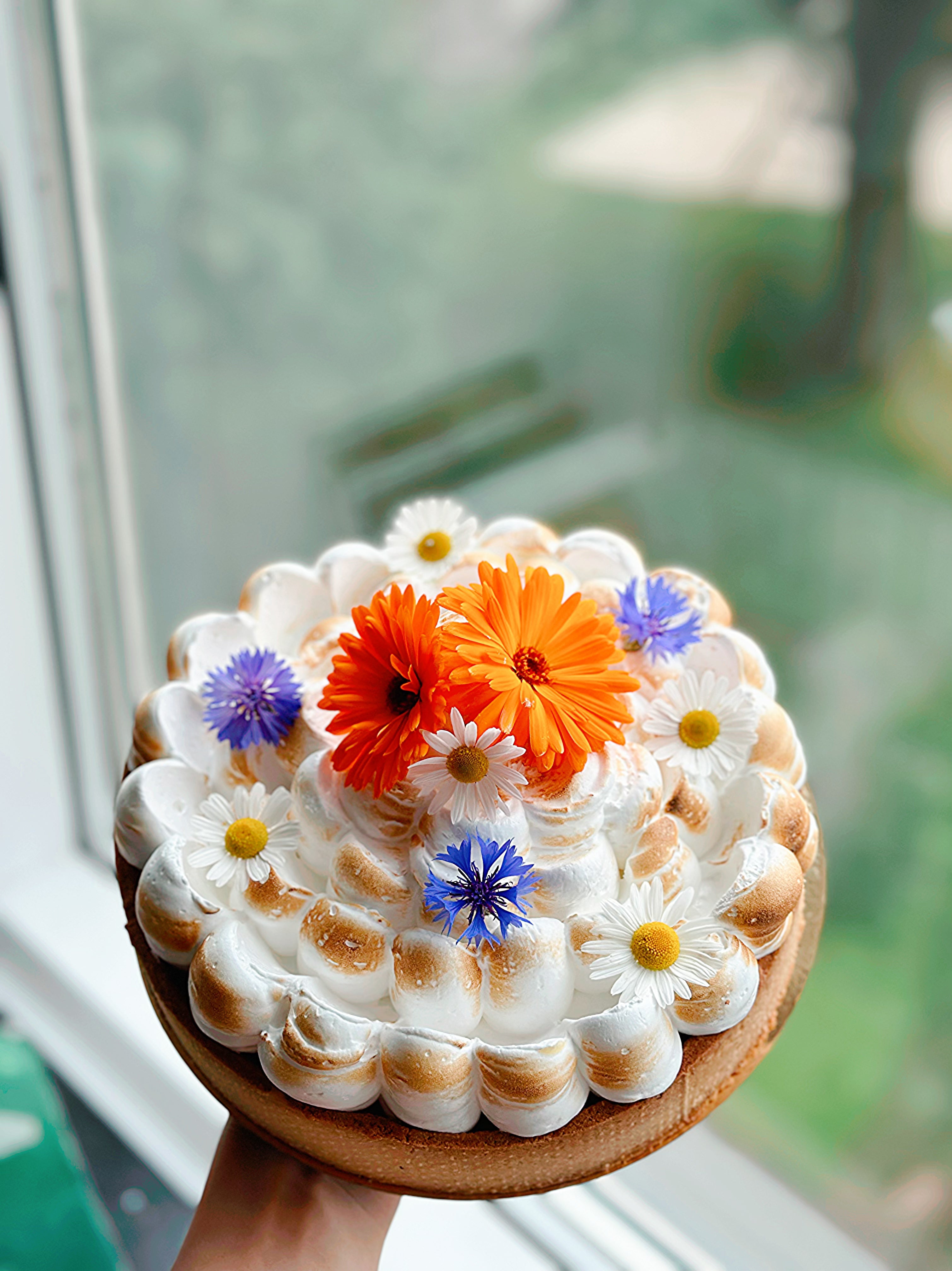 A gluten-free celebration cake topped with edible flowers, from our cakes and pies collection by Gluten Tag in Copenhagen.