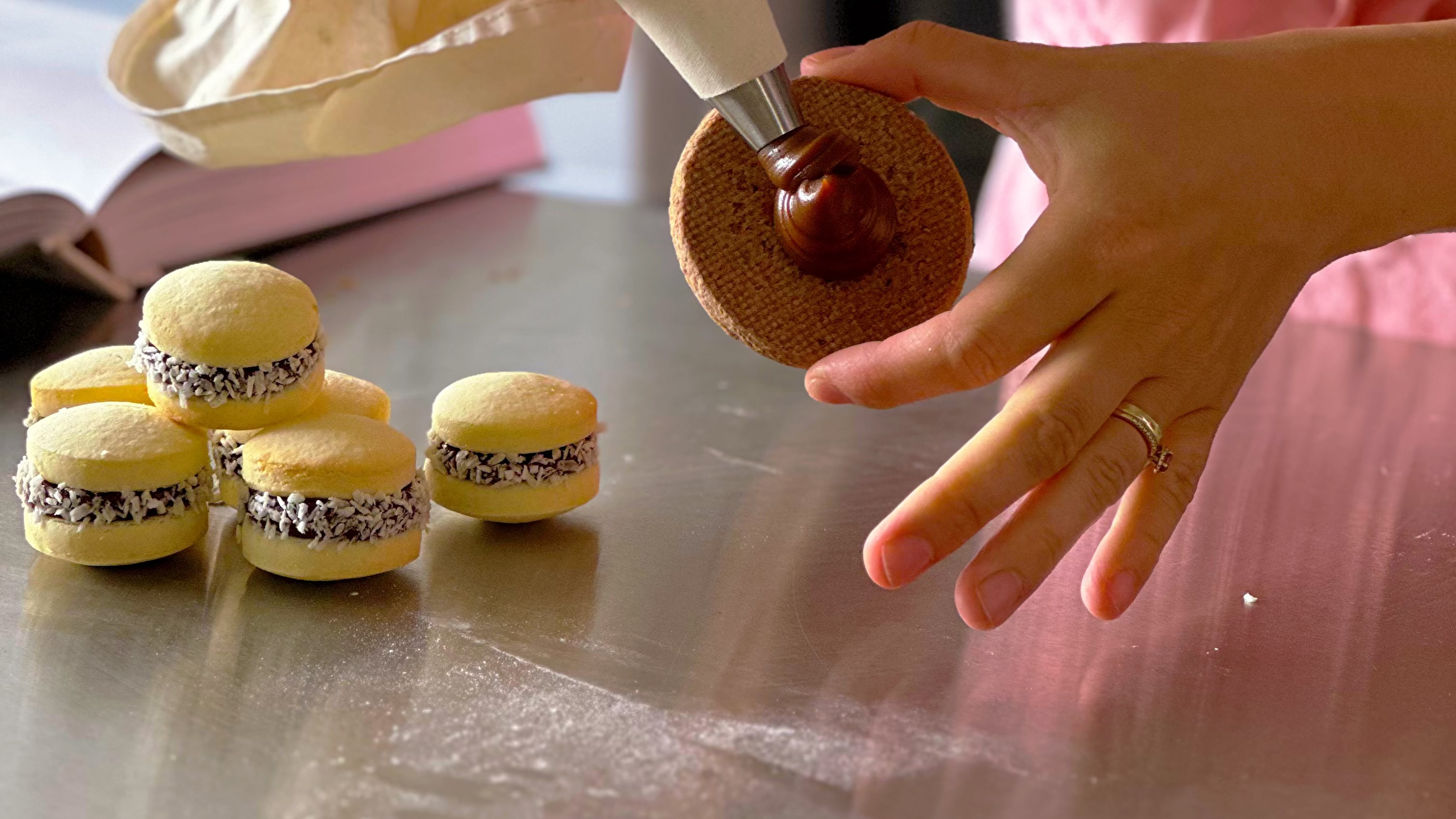 Hand piping dulce de leche on a gluten free alfajor cookie at Gluten Tag, a dedicated gluten free bakery in Copenhagen