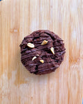 Vegan gluten-free cookie broken in half showing creamy peanut butter center and dark chocolate chips, baked Levain-style by Gluten Tag in Copenhagen.